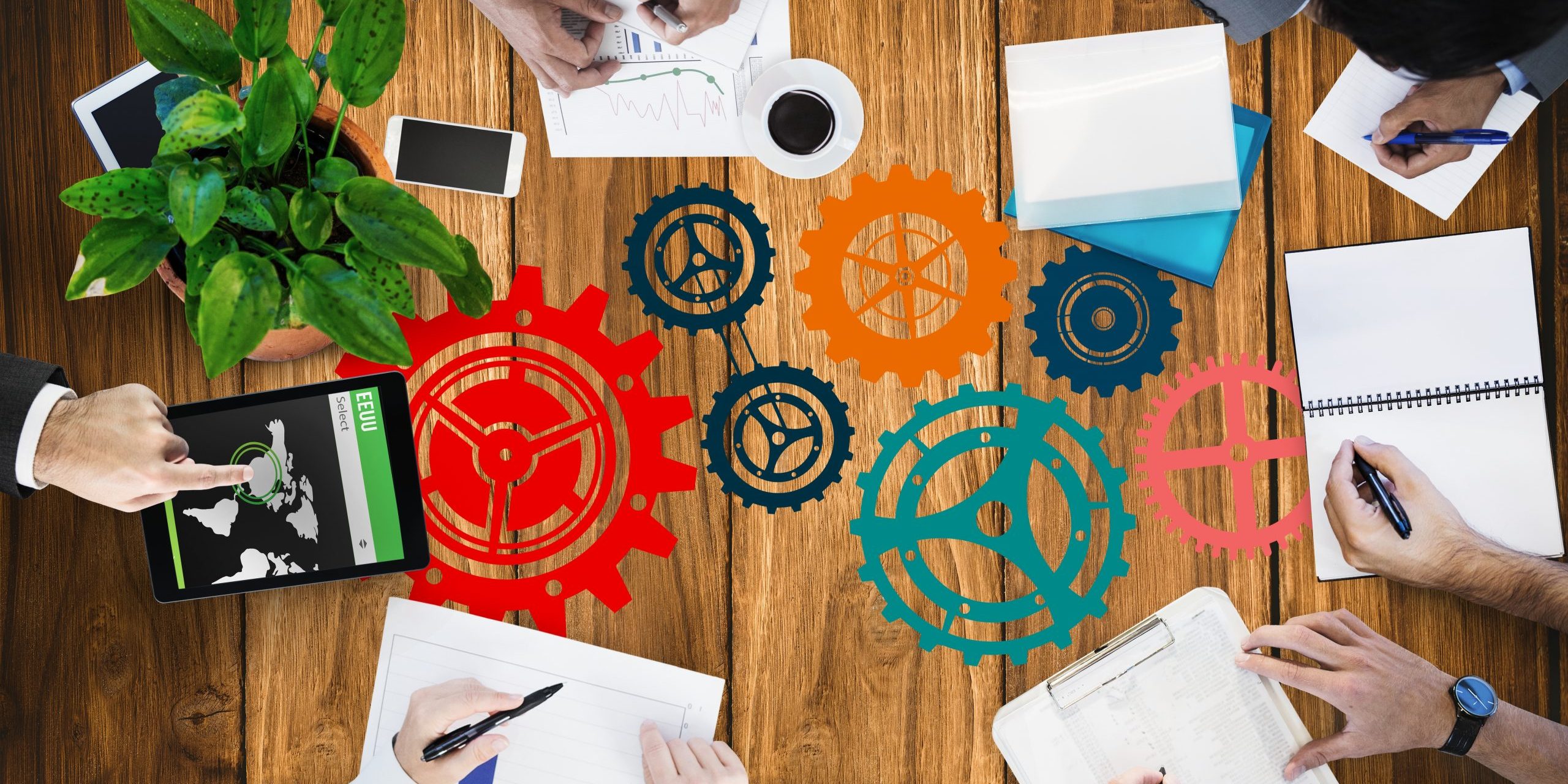 digital composite of hands using notebooks and devices on desk background